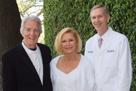 couple smiling with doctor in white coat
