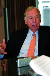 T. Boone Pickens talking at a table wearing an orange tie