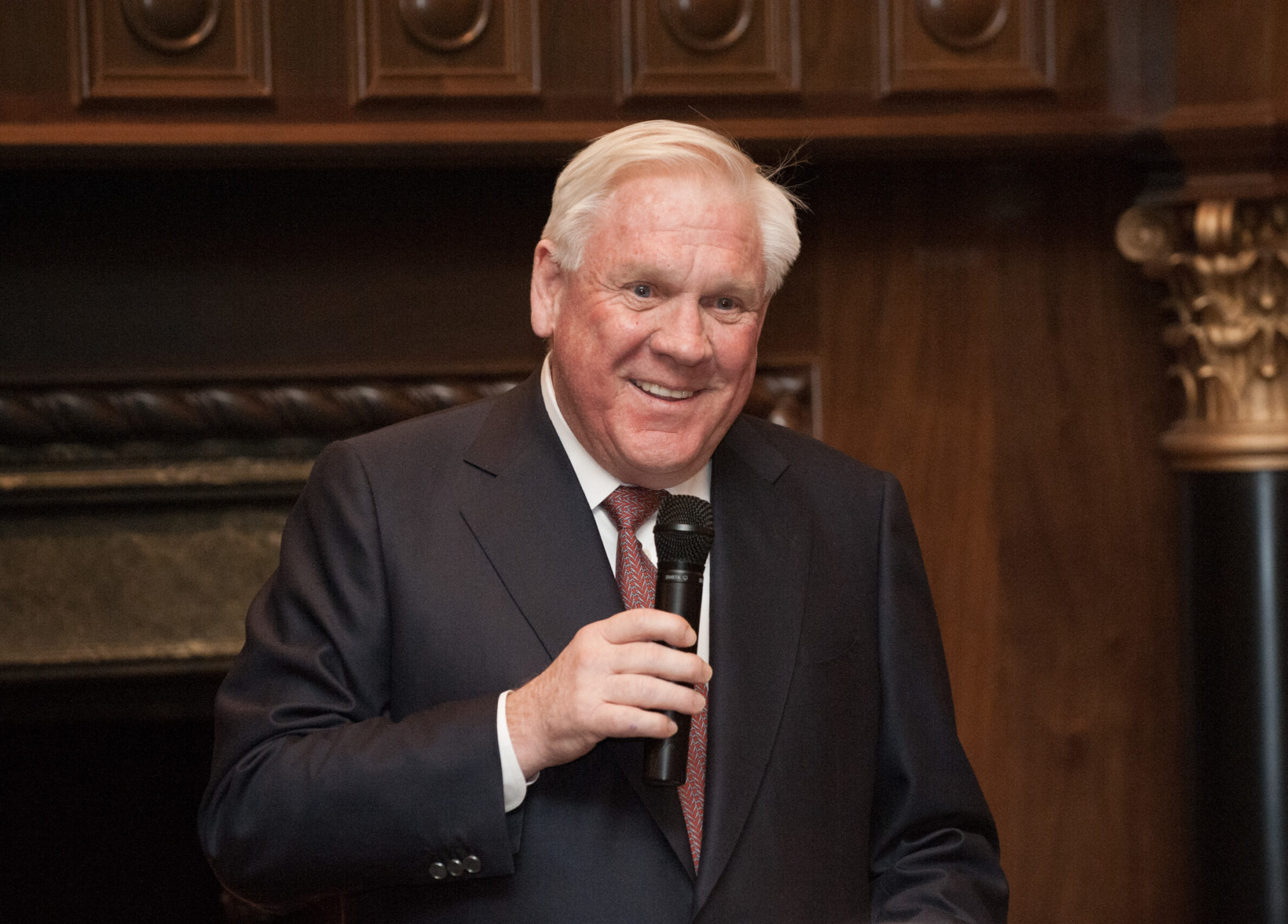 Harlan Crow holding a microphone