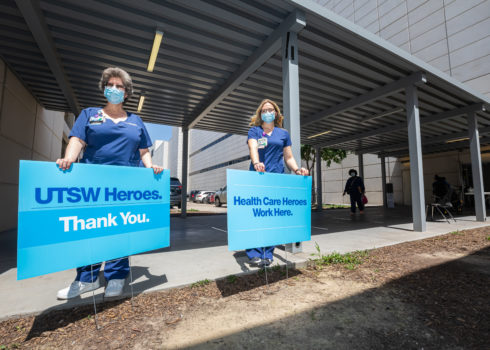 UTSW healthcare workers standing outside in front of thank you signs