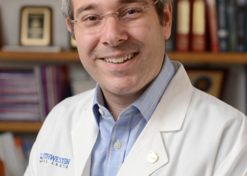 Dr. David Greenberg smiling in a white coat