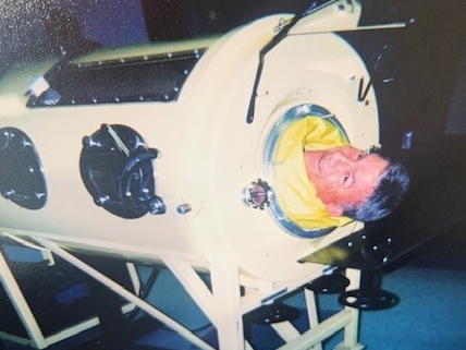 Dr. Viroslav poses in an iron lung, brought to St. Paul Hospital for treatment of a young patient with polio and other pulmonary diseases.