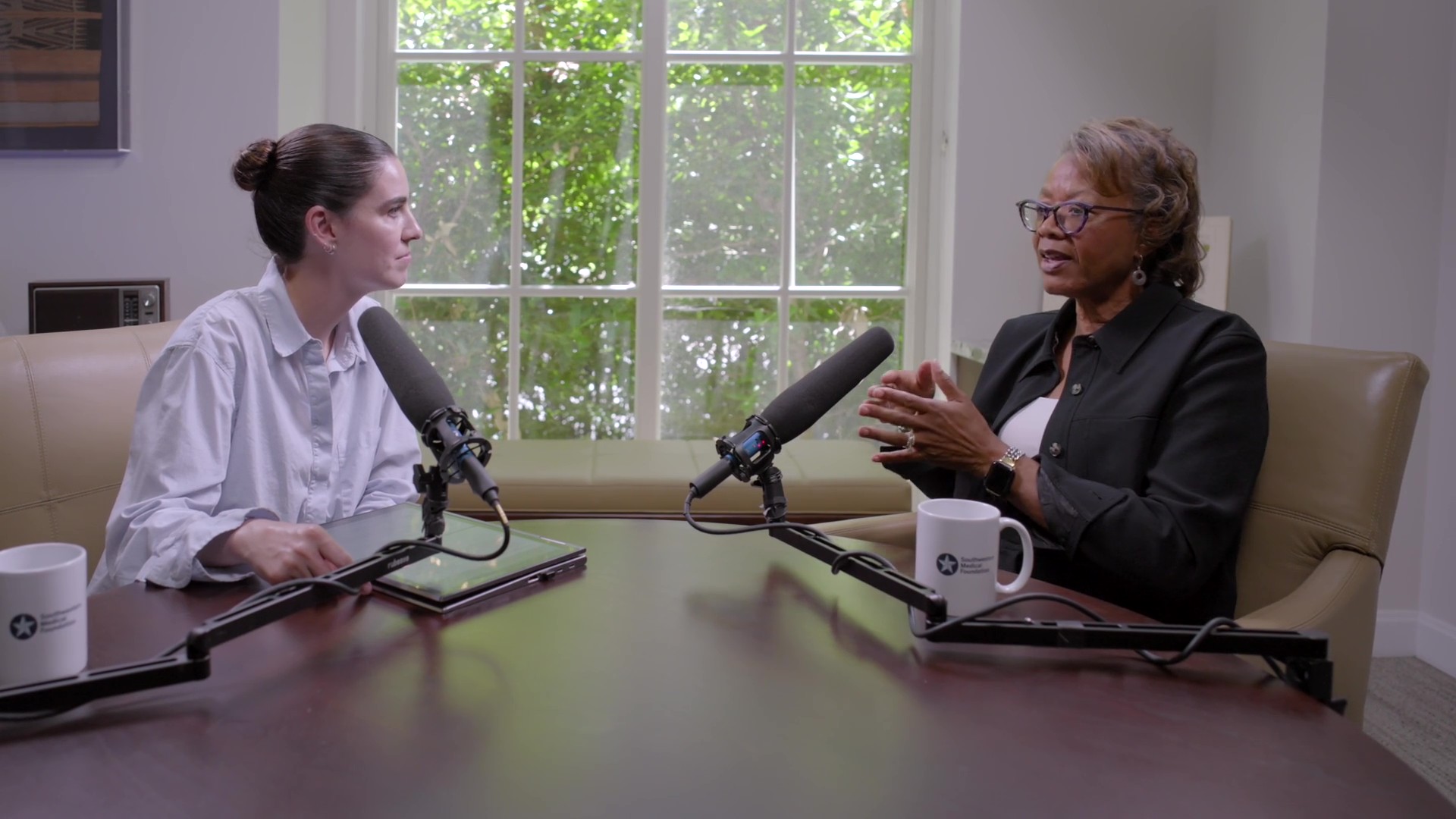 alfreda norman sitting next to lili clark in an office building recording a podcast.