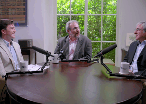 Three men sitting at a table discussing the biotech valley of death