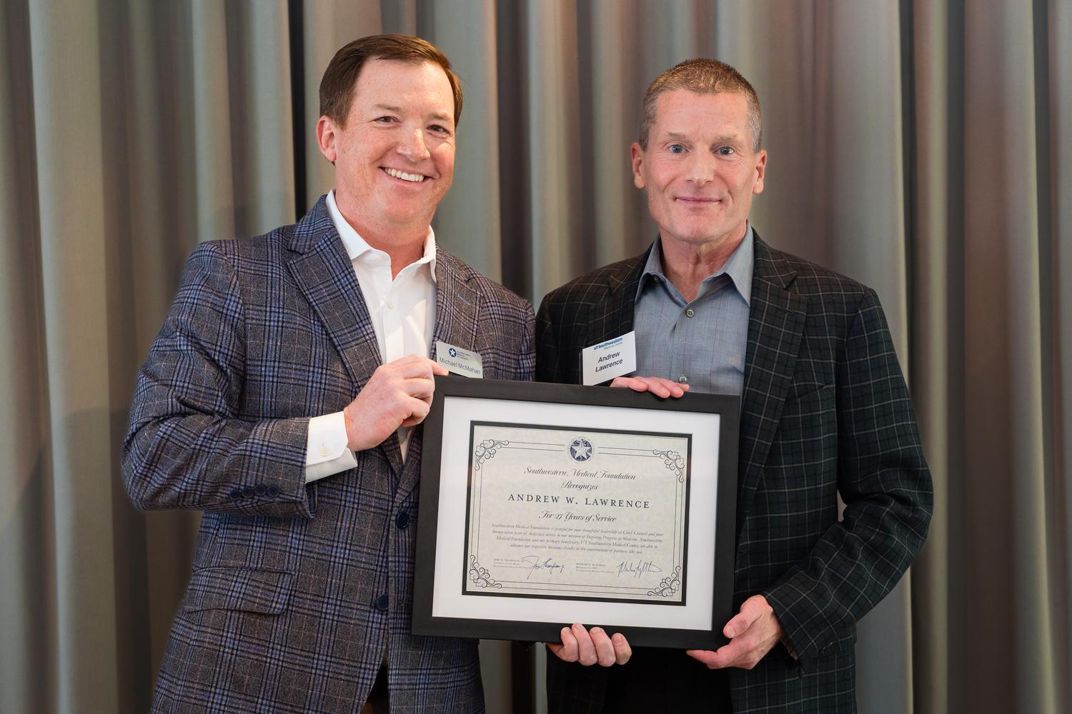 Two men holding a framed certificate at the Estate Planning Council luncheon for southwestern medical foundation.